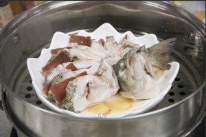 將鱸魚成花狀擺好，將火腿切片放入各縫隙中，放入鍋中隔水蒸12分鐘拿出，撒上蔥花即可。