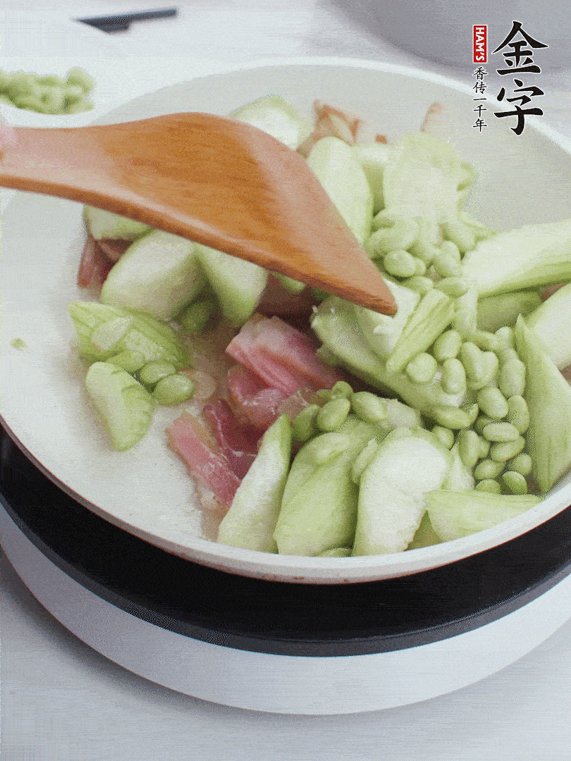 依次下絲瓜、青豆翻炒，炒至絲瓜打蔫縮小。