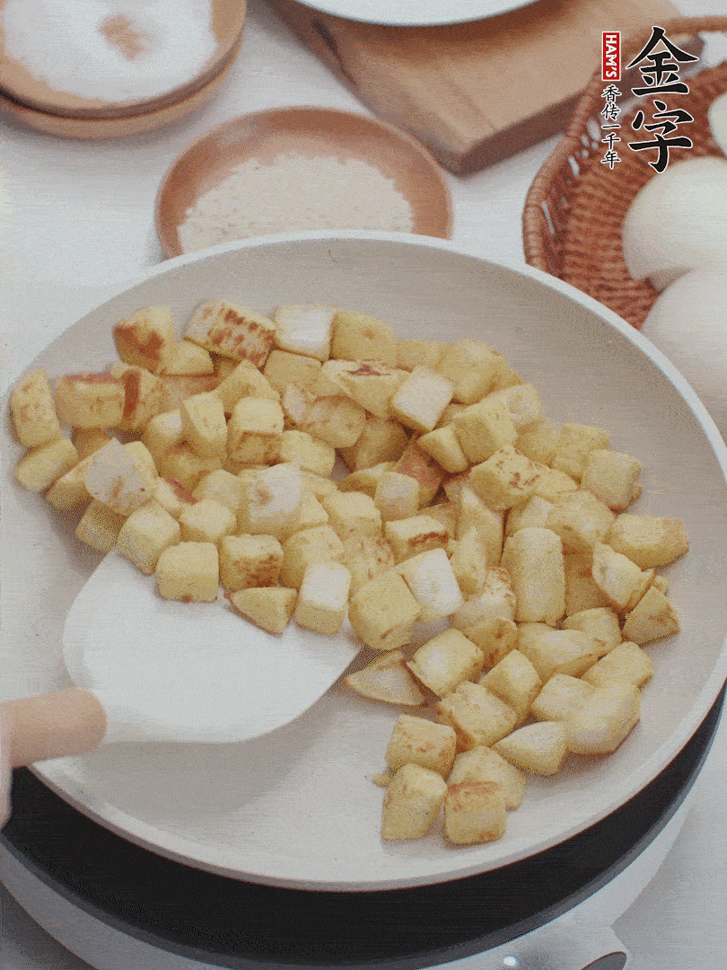 起鍋熱油，倒入饅頭丁，小火煎至蛋液凝固定型再翻面，饅頭丁部煎至金黃時盛起待用。