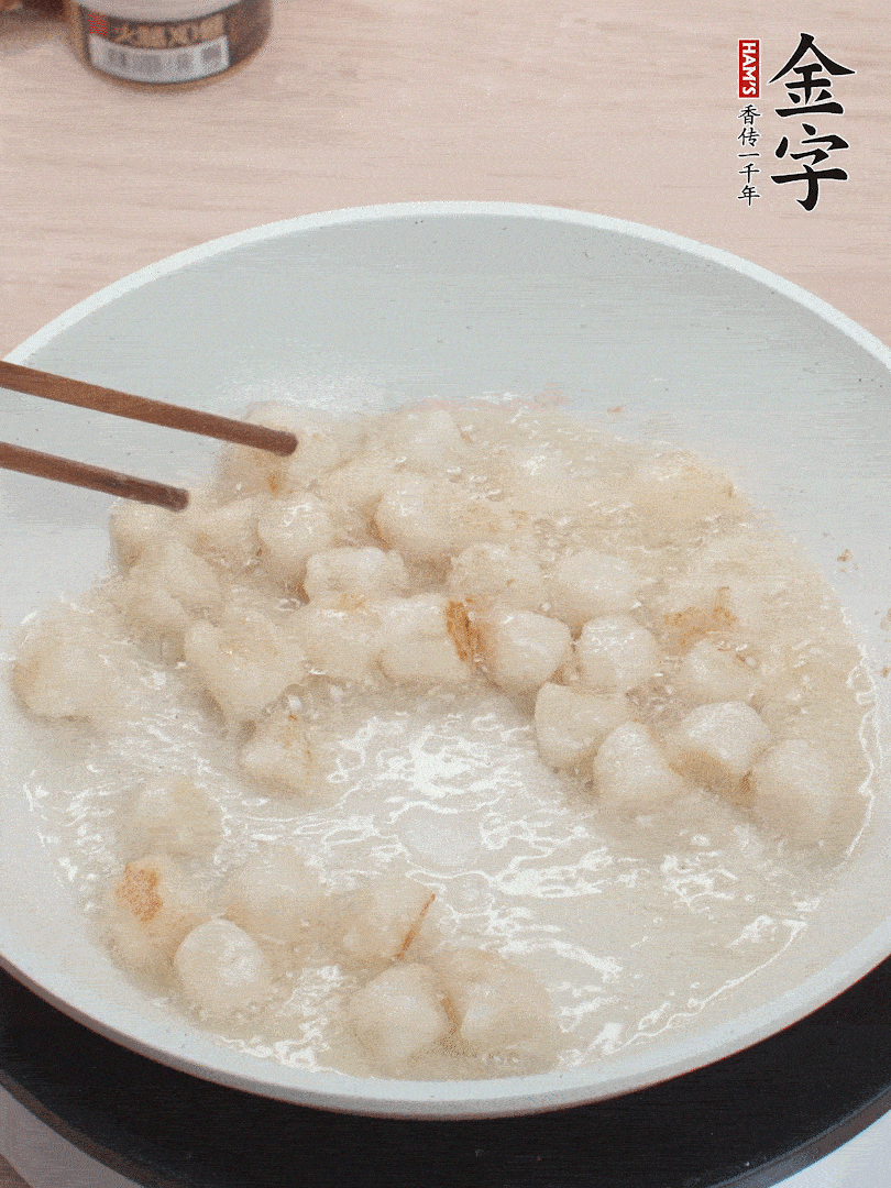 油溫4成熱，鮮貝蘸干淀粉下鍋煎，一面微黃后翻面。