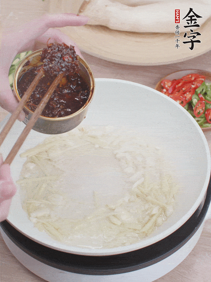 起鍋熱油，姜蒜、金字火腿干貝醬煸香。