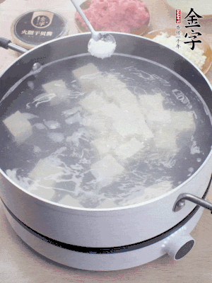豆腐切成大小均勻正方體，鍋內(nèi)放水，加一點鹽焯水10秒。