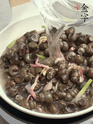 倒處理干凈的螺螄翻炒，加3勺料酒。加清水蓋過螺螄，中火蓋蓋煮5分鐘。